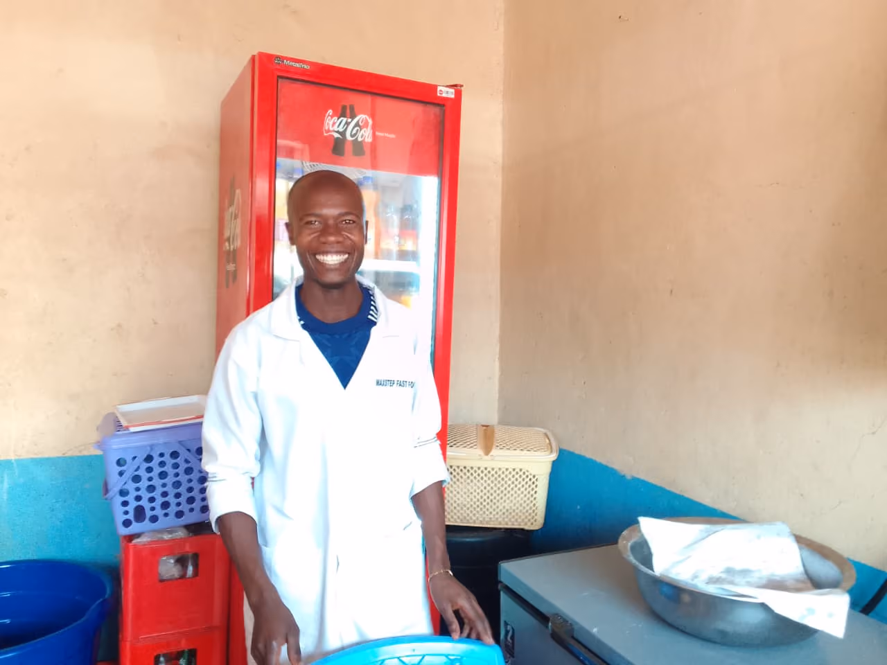 A food worker standing in a small working kitchen.